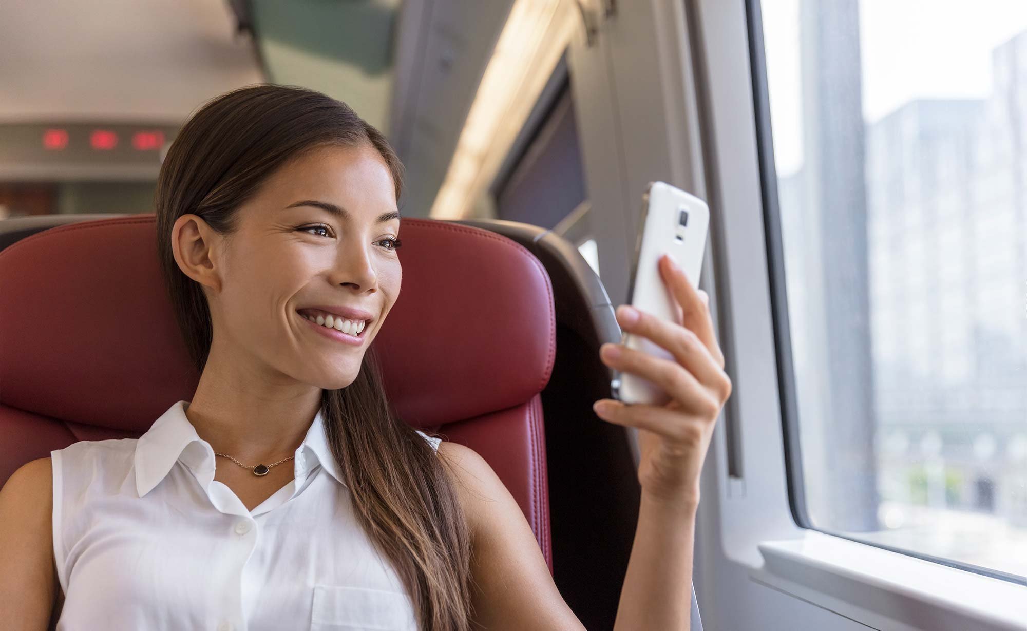 Happy employee using their mobile on the train | Employee benefits platform provider checklist - FlexGenius